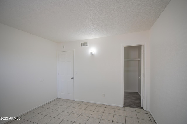 2846 N 46th Ave Unit 7, Phoenix, AZ 85035 - unfurnished room featuring light tile patterned flooring, a textured ceiling, and baseboards