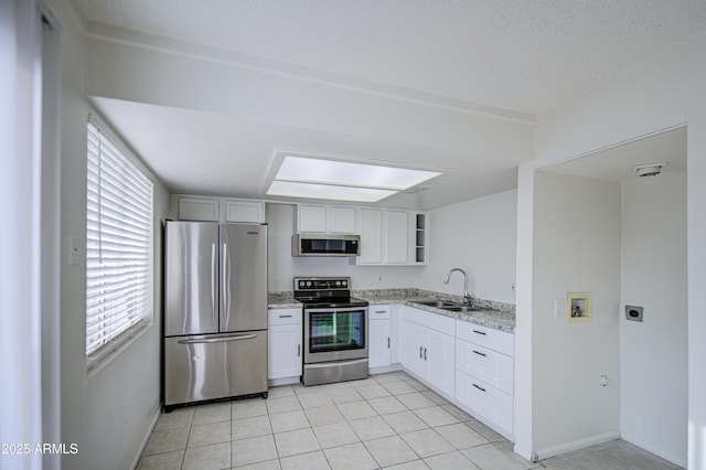 2846 N 46th Ave Unit 7, Phoenix, AZ 85035 - kitchen featuring stainless steel appliances, a sink, light stone countertops, light tile patterned floors, and white cabinets