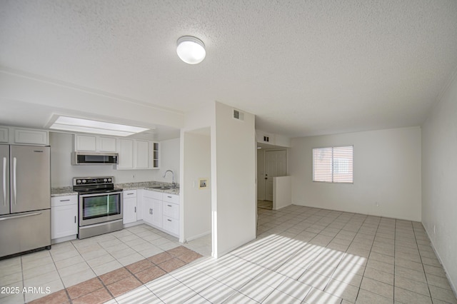 2846 N 46th Ave Unit 7, Phoenix, AZ 85035 - kitchen featuring appliances with stainless steel finishes, a sink, light tile patterned flooring, light stone counters, and a textured ceiling