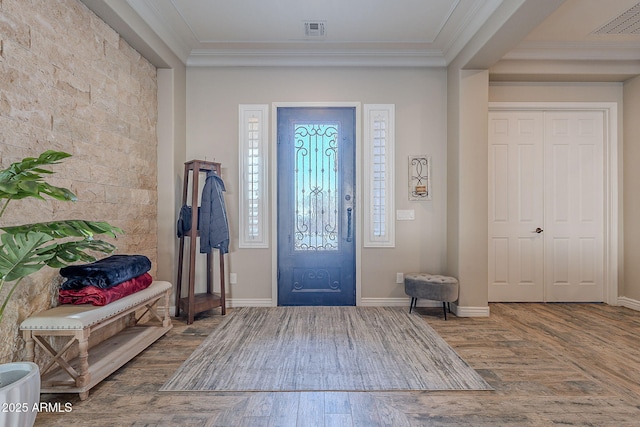 entrance foyer with ornamental molding and hardwood / wood-style floors