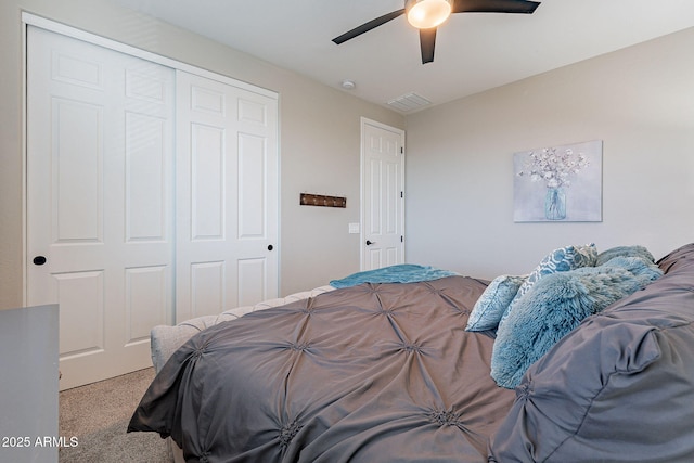 carpeted bedroom with ceiling fan and a closet