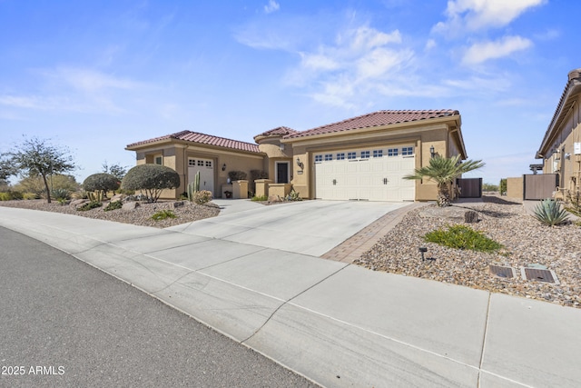 mediterranean / spanish-style home with central air condition unit, stucco siding, concrete driveway, a garage, and a tiled roof