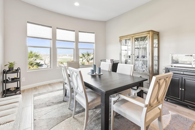 dining room with recessed lighting, light wood-style flooring, and baseboards