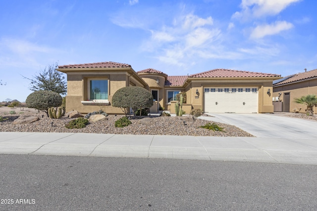 mediterranean / spanish-style house featuring an attached garage, driveway, a tile roof, and stucco siding