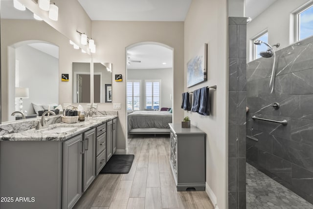 ensuite bathroom with plenty of natural light, a sink, wood tiled floor, and ensuite bathroom