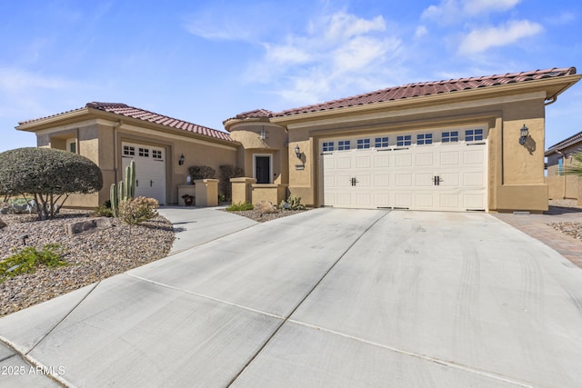 mediterranean / spanish-style home with a garage, concrete driveway, a tile roof, and stucco siding