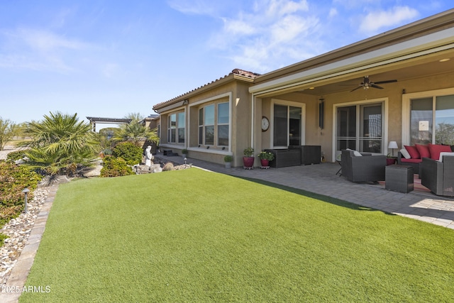 rear view of property with a patio, an outdoor hangout area, a ceiling fan, a yard, and stucco siding