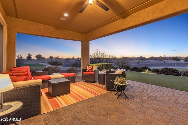 patio terrace at dusk featuring ceiling fan and outdoor lounge area