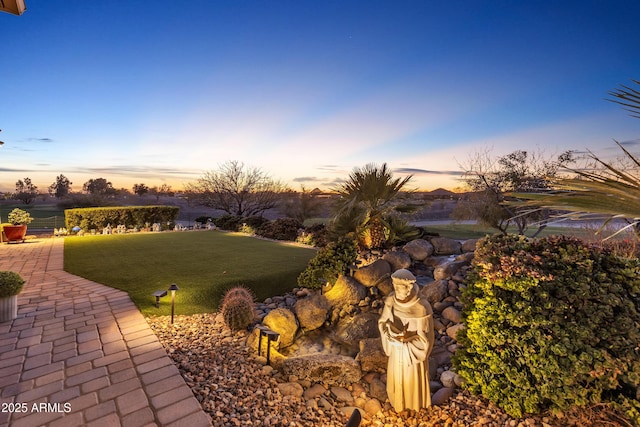 yard at dusk featuring a patio