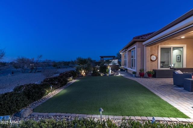 yard at twilight featuring a patio area