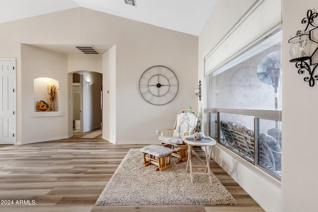 living area with light hardwood / wood-style floors and lofted ceiling