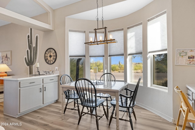 dining space with an inviting chandelier and light hardwood / wood-style flooring