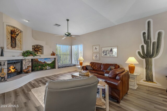 living room featuring a fireplace, hardwood / wood-style flooring, and ceiling fan