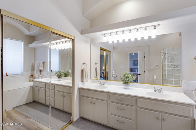 bathroom featuring a bathing tub, vanity, and hardwood / wood-style flooring