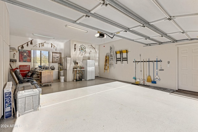 garage with a garage door opener and white refrigerator