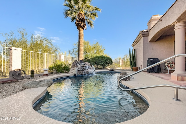 view of swimming pool with a patio and pool water feature