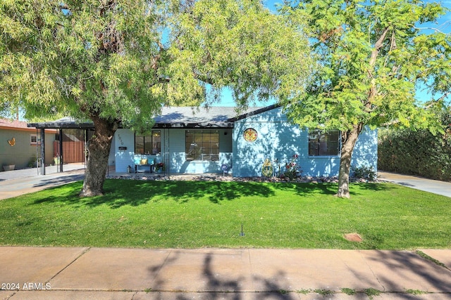 view of front of home with a carport and a front yard