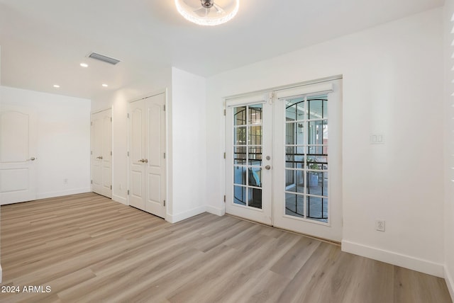 unfurnished room with french doors and light hardwood / wood-style flooring