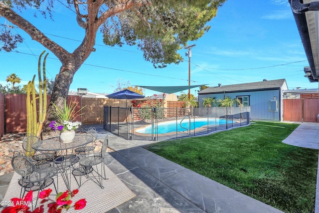 view of swimming pool with a lawn, a patio, and an outdoor structure