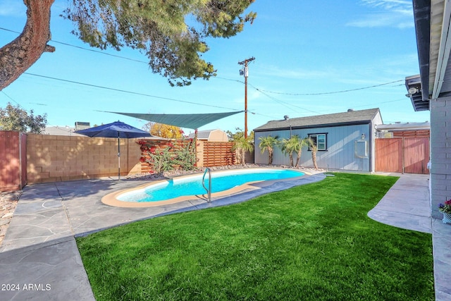 view of swimming pool featuring an outdoor structure and a yard