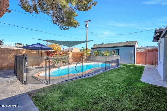 view of swimming pool featuring a patio area, an outdoor structure, and a lawn