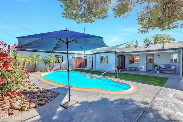 view of pool featuring a lawn and a patio