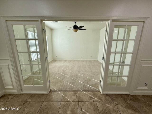 carpeted empty room featuring ceiling fan and french doors