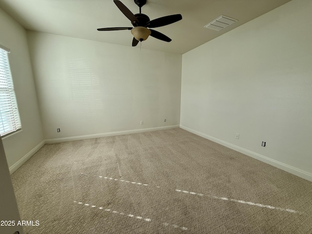 carpeted empty room with ceiling fan and plenty of natural light