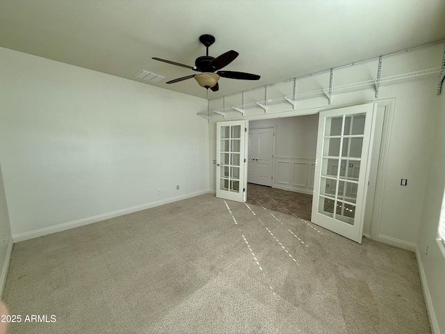 carpeted empty room with ceiling fan and french doors