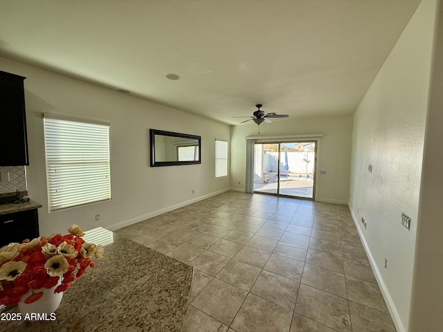 unfurnished living room with ceiling fan and light tile patterned flooring