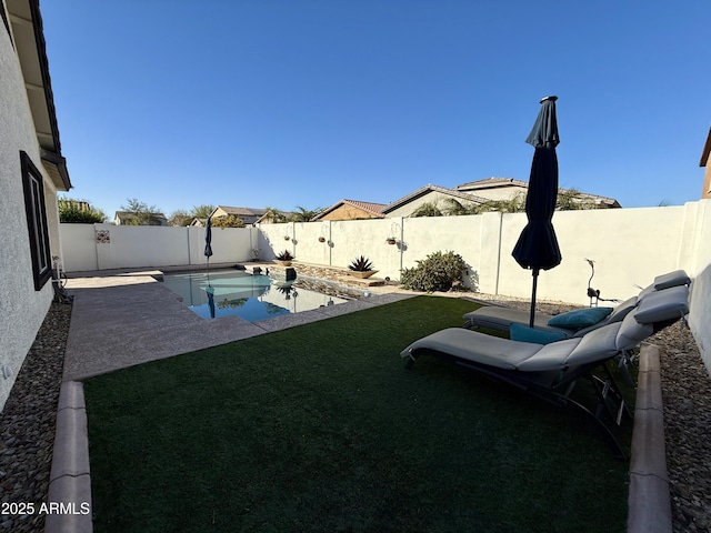 view of yard featuring a fenced in pool and a patio