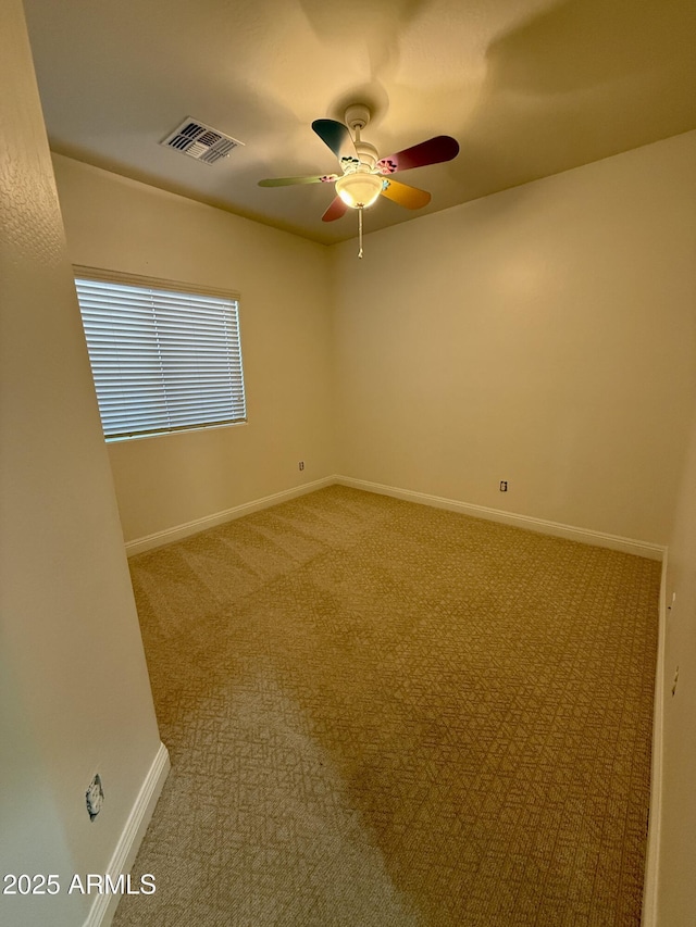 carpeted spare room with ceiling fan