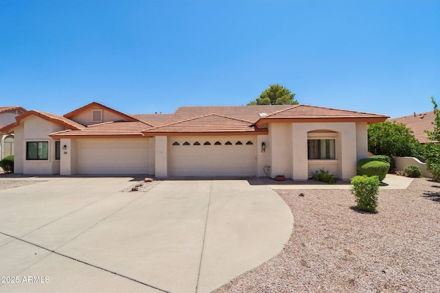2055 N 56th St Unit 15, Mesa, AZ 85215 - mediterranean / spanish house featuring concrete driveway, a garage, stucco siding, and a tile roof