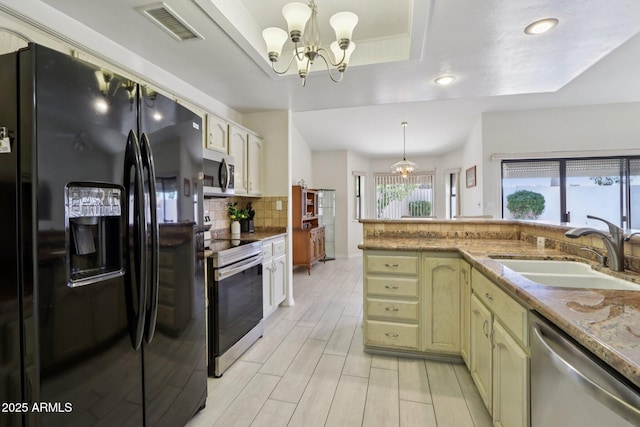 2055 N 56th St Unit 15, Mesa, AZ 85215 - kitchen with appliances with stainless steel finishes, a tray ceiling, a chandelier, tasteful backsplash, and recessed lighting