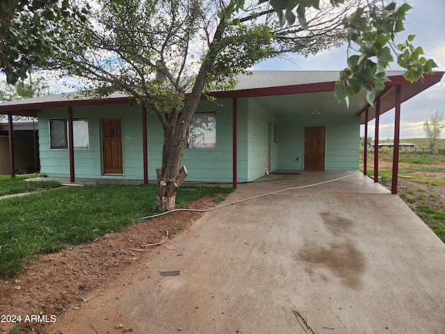 ranch-style home with a front yard and a carport