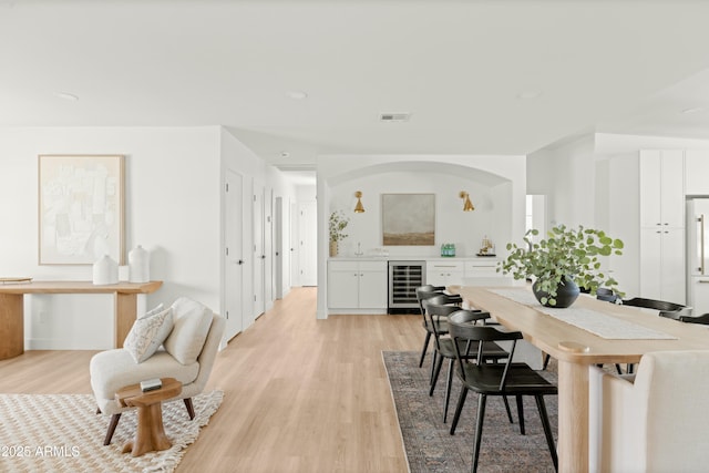 dining area featuring light wood-type flooring and wine cooler