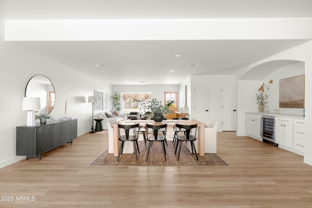 dining room with light wood-type flooring and beverage cooler