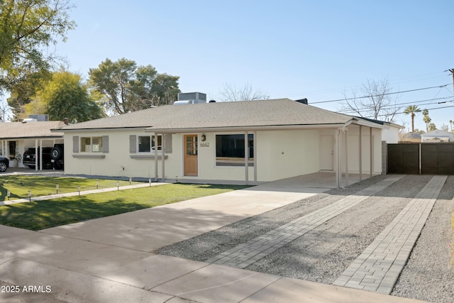 ranch-style house featuring a front lawn and a carport