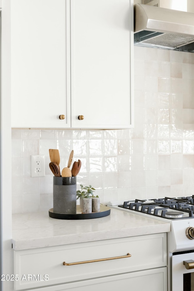 kitchen featuring ventilation hood, white cabinetry, backsplash, and white range with gas cooktop