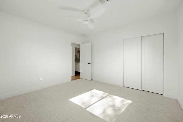 unfurnished bedroom with ceiling fan, a closet, and light carpet