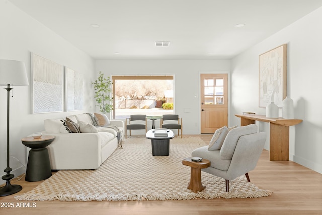 living room with a wealth of natural light and light hardwood / wood-style floors