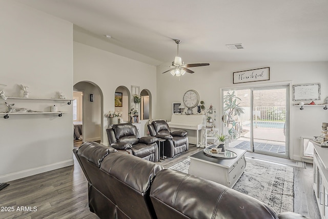 living area with lofted ceiling, wood finished floors, visible vents, arched walkways, and a ceiling fan