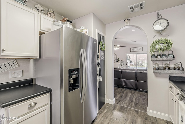 kitchen with stainless steel appliances, wood finished floors, visible vents, a ceiling fan, and white cabinets