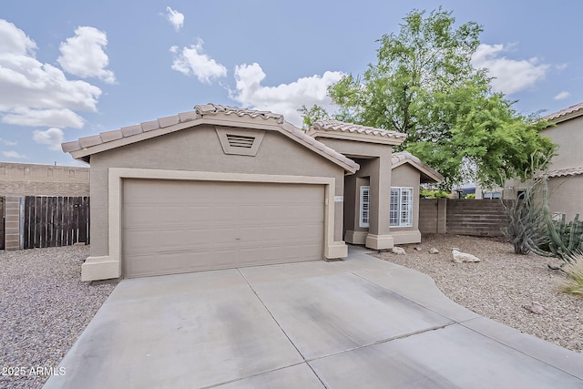 view of front of house featuring fence, driveway, a garage, stucco siding, and a tiled roof