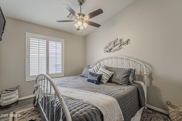 bedroom featuring baseboards, lofted ceiling, a ceiling fan, and wood finished floors