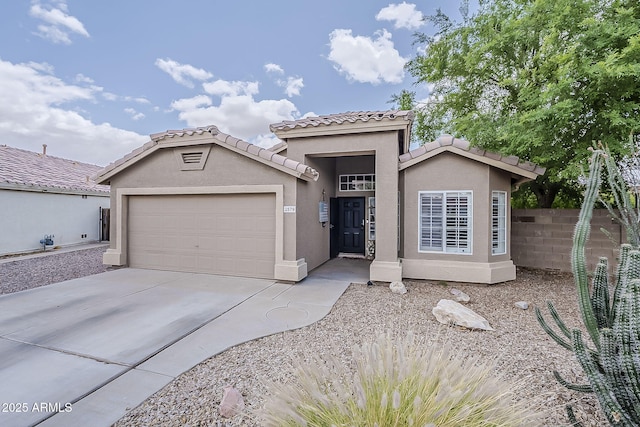 view of front of property with a garage, stucco siding, a tile roof, fence, and concrete driveway