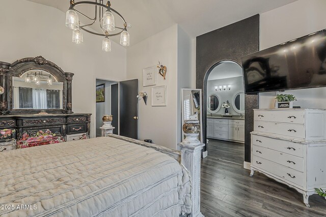 bedroom with ensuite bath, a high ceiling, and dark wood-type flooring