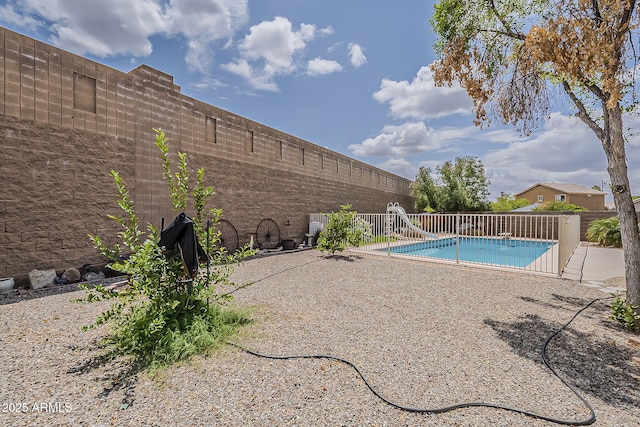 view of pool featuring a patio, a fenced in pool, a water slide, and a fenced backyard
