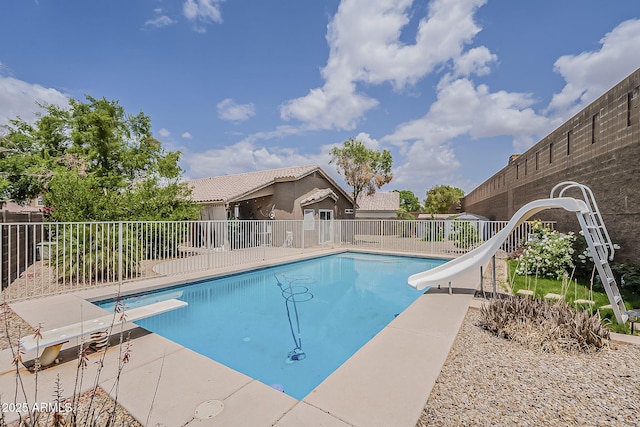 view of swimming pool with a water slide and fence