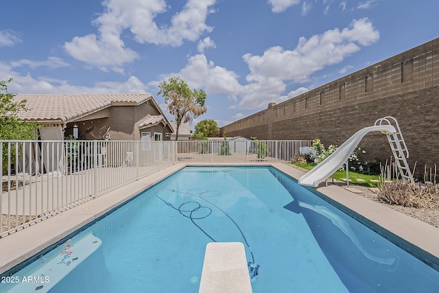 view of pool featuring fence, a fenced in pool, a diving board, and a water slide